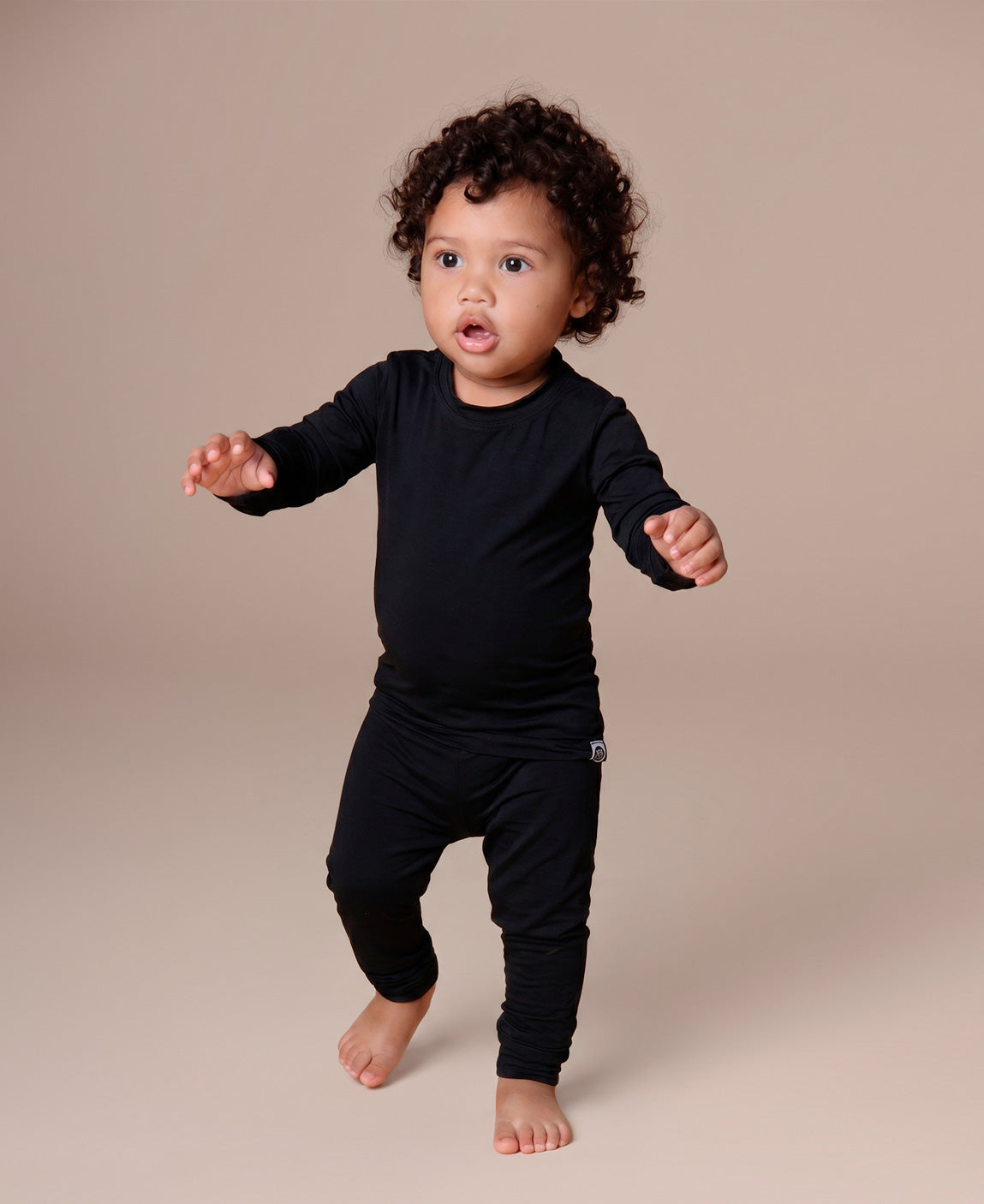 Blusa Térmica Infantil Liso Preto MiniMalista — modelagem raglan justa segunda-pele com manga longa e gola redonda em ribana, ideal para usar por baixo de outras roupas no frio intenso ou sozinha em dias amenos. Para menino, menina e unissex.