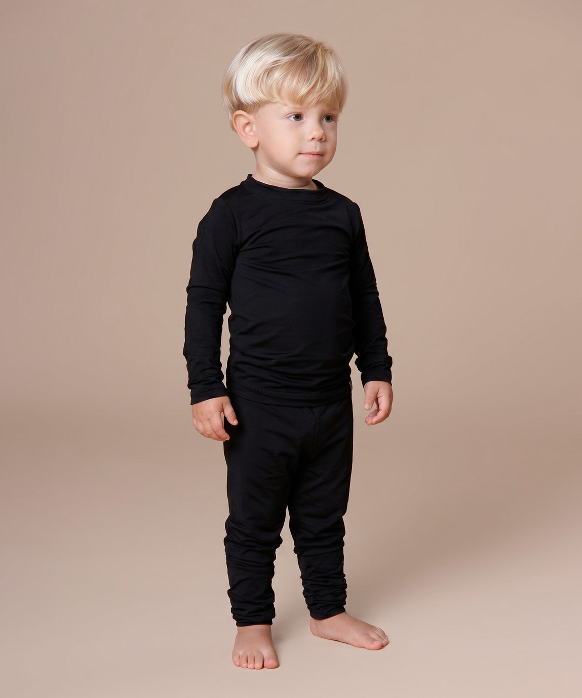 Blusa Térmica Unissex Liso Preto MiniMalista vista costas — manga longa que cobre os pulsos, gola redonda em ribana, comprimento perfeito pra entrar na calça. Sistema de 3 camadas, base do guarda-roupa de inverno infantil.
