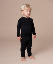 Blusa Térmica Unissex Liso Preto MiniMalista vista costas — manga longa que cobre os pulsos, gola redonda em ribana, comprimento perfeito pra entrar na calça. Sistema de 3 camadas, base do guarda-roupa de inverno infantil.