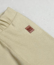 Detalhes da Calça Slim Canelada Liso Avelã - ribana elástica, cós com elástico macio sem cadarço, etiqueta de courino - avelã terroso - MiniMalista Baby