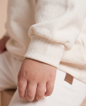 MiniMalista Conjunto Moletom + Calça Canelada Liso Branco Off vista frontal. Conjunto infantil para bebê e criança em 100% algodão peluciado e canelado, look monocromático atemporal, hoodie + leggings clássico unissex.