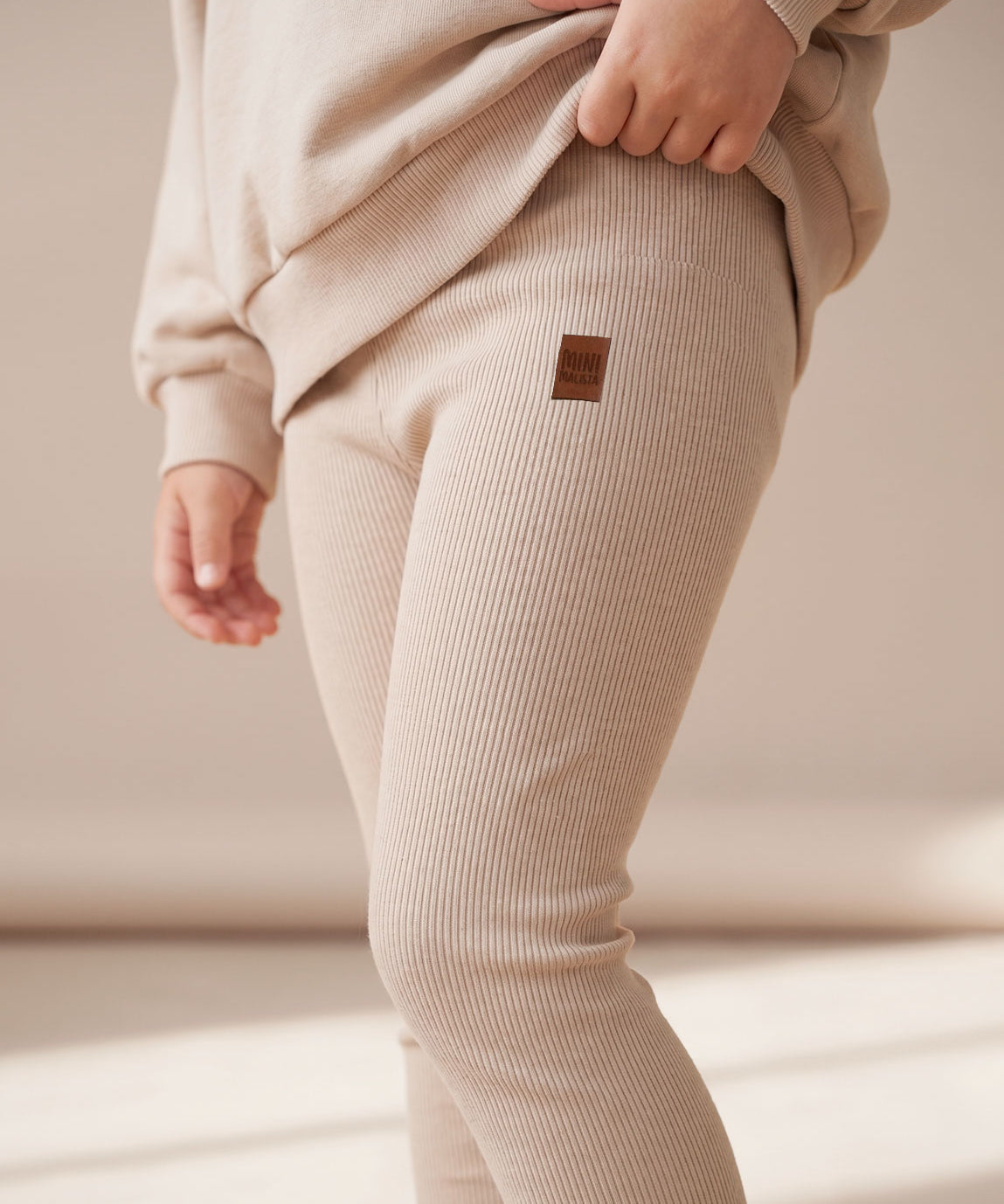 MiniMalista Conjunto Moletom + Calça Canelada Liso Bege Claro vista frontal. Look monocromático infantil 100% algodão, moletom peluciado oversized + calça canelada slim ajustada, conjunto unissex menino e menina para bebê e criança, do bebê de 0-3 meses aos 5-6 anos.