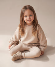 MiniMalista Conjunto Moletom + Calça Canelada Liso Bege Claro — detalhe calça canelada slim em ribana elástica, ajuste perfeito no tornozelo. Conjunto infantil 100% algodão unissex, look quentinho e acolhedor de inverno para bebê e criança, estética escandinava minimalista.