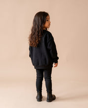 MiniMalista Conjunto Moletom + Calça Canelada Liso Preto vestido em criança. Look elegante infantil 100% algodão, moletom peluciado e calça canelada slim no mesmo tom, conjunto unissex menino e menina.