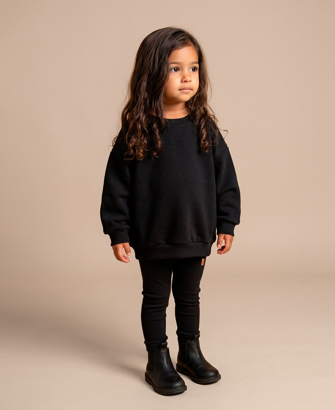 MiniMalista Conjunto Moletom + Calça Canelada Liso Preto vista frontal. Conjunto infantil para bebê e criança em 100% algodão peluciado e canelado, look monocromático atemporal, hoodie + leggings clássico unissex.