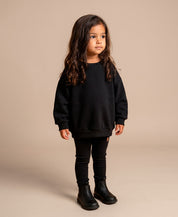 MiniMalista Conjunto Moletom + Calça Canelada Liso Preto vista frontal. Conjunto infantil para bebê e criança em 100% algodão peluciado e canelado, look monocromático atemporal, hoodie + leggings clássico unissex.